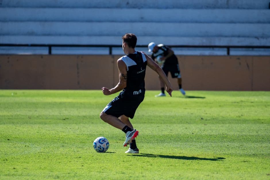 Futbolista practicando técnica en un campo abierto y despejado
