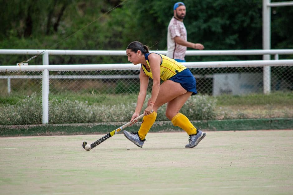 Jugadora de hockey en acción jugando al aire libre en cancha