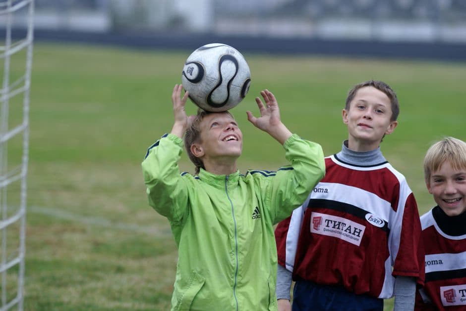 Un grupo de niños jugando al fútbol en una cancha abierta