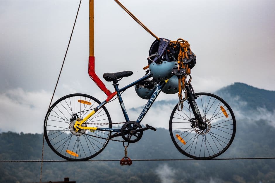 Bicicleta suspendida con cascos en montaña brumosa y nebulosa