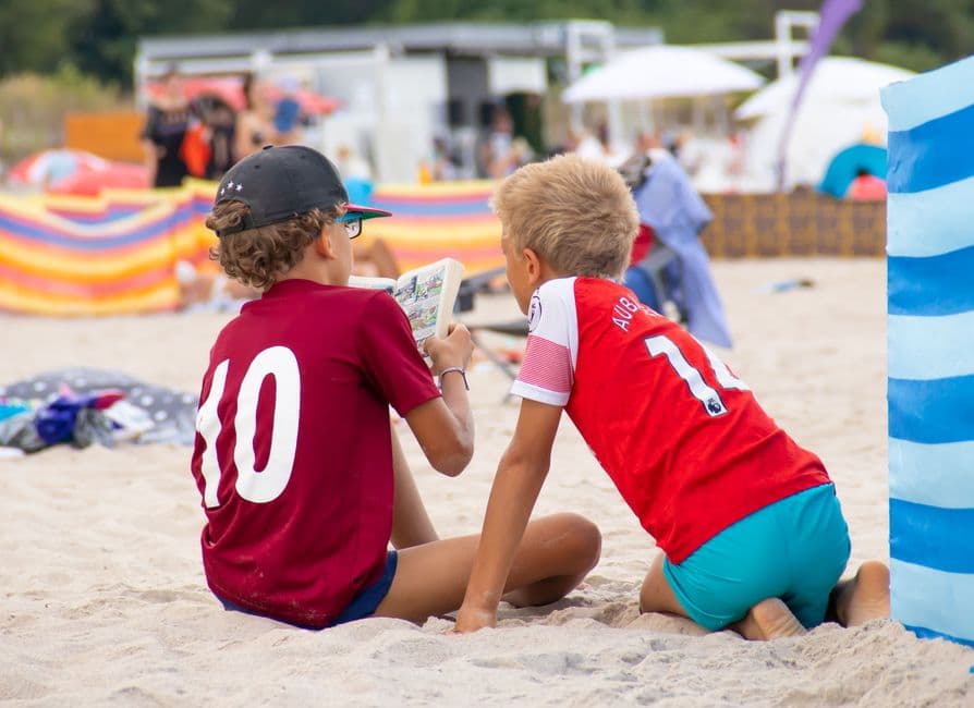 Niños sentados en la arena de la playa