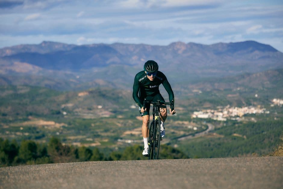 Ciclista ascendiendo una colina con bicicleta de carretera