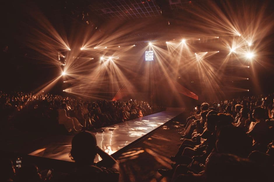 Pasarela de moda con iluminación dramática en desfile