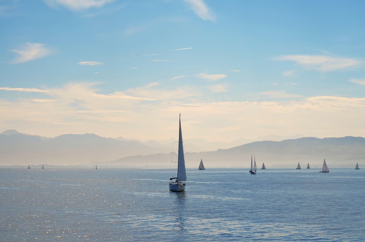 Veleros blancos navegando en el lago Constanza bajo un cielo azul
