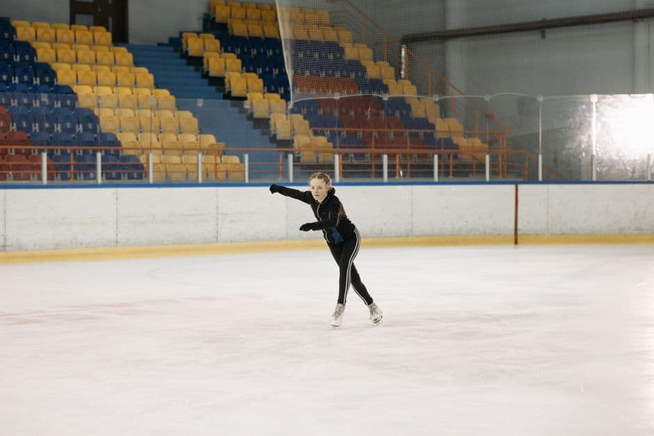 Joven patinadora sobre la pista de hielo en movimiento