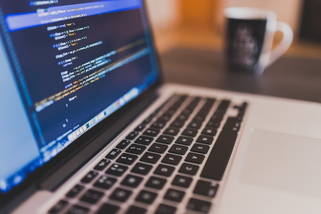 Persona escribiendo código en una computadora portátil