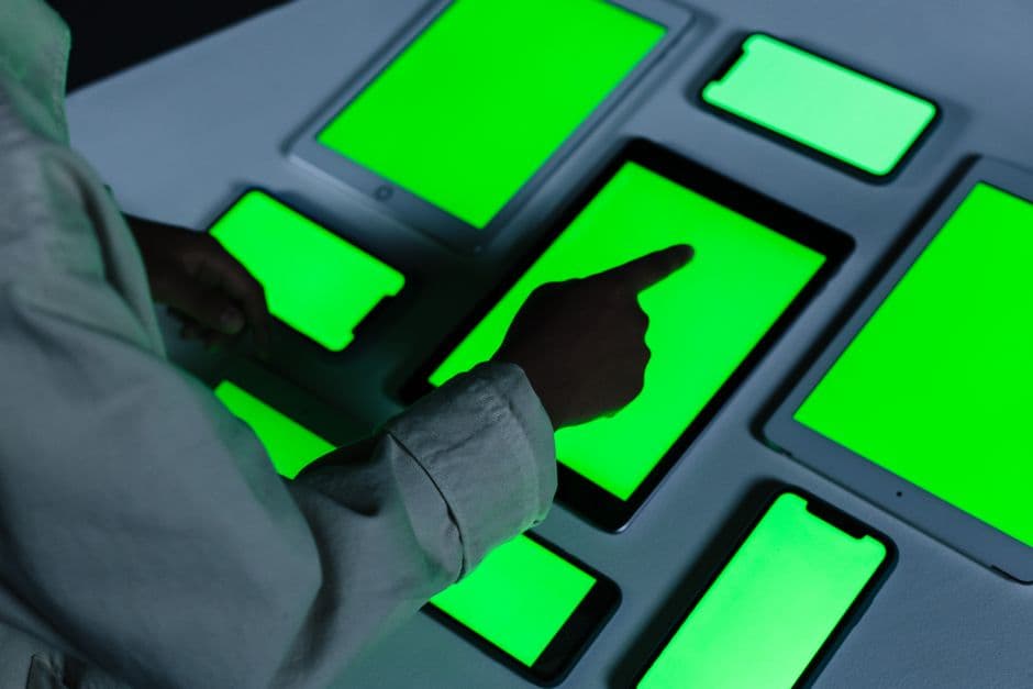 Mano tocando una tableta digital con pantalla verde