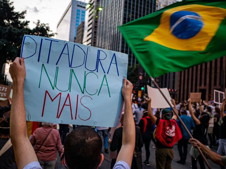 Personas sosteniendo una bandera de colores azul y verde