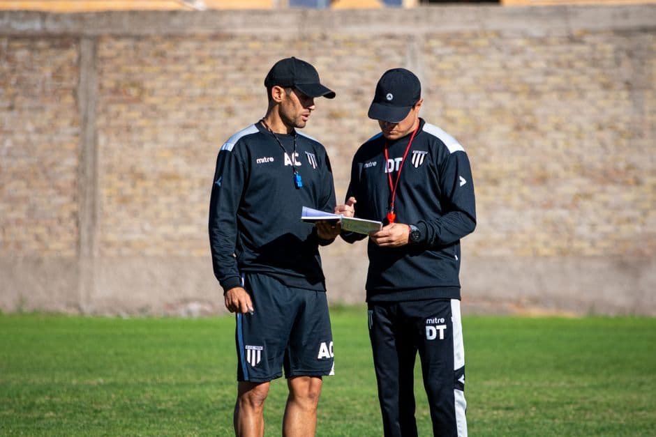 Entrenadores de fútbol discutiendo estrategia al aire libre