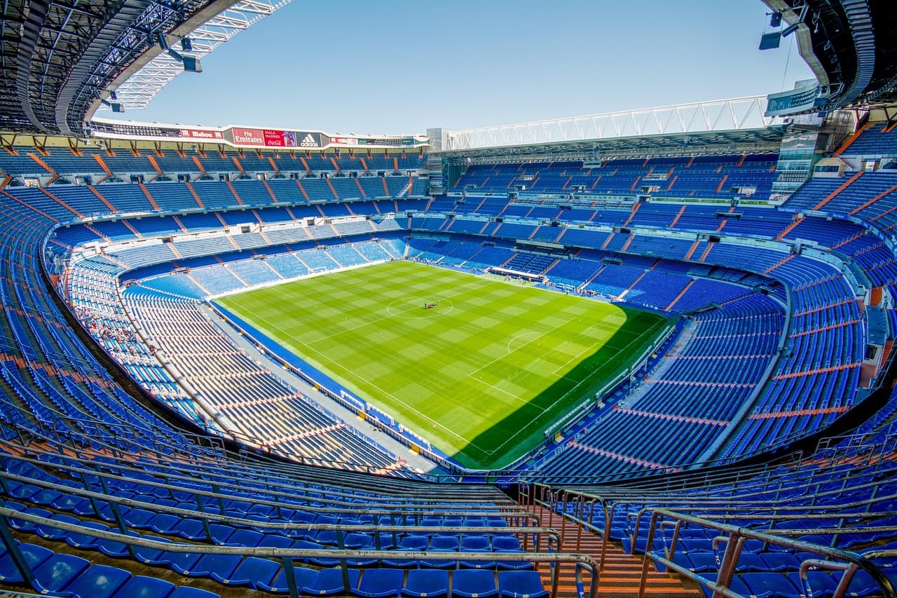 Filas de asientos de grada vacía en un estadio bajo luz natural