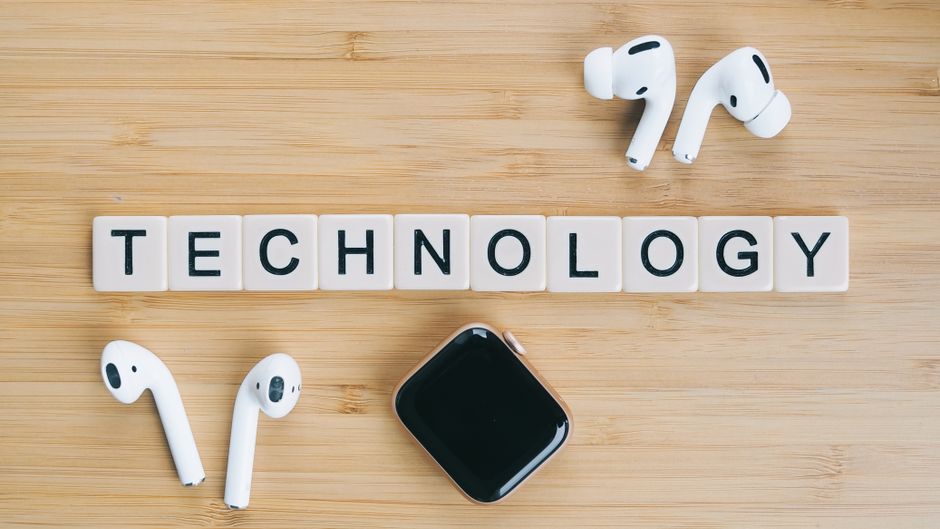 Auriculares inalámbricos y reloj inteligente junto a palabra tecnología