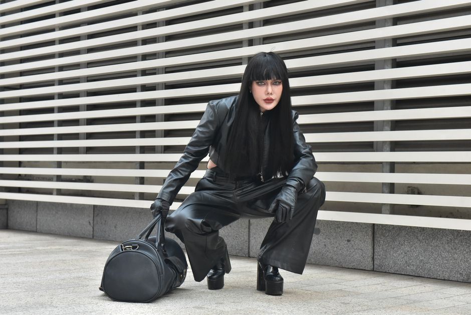 Modelo de estilo moderno lleva chaqueta de cuero negro en un entorno al aire libre