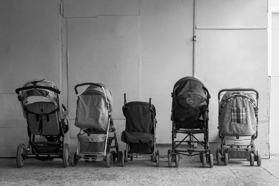 Una fila de cochecitos de bebé en un pasillo de edificio