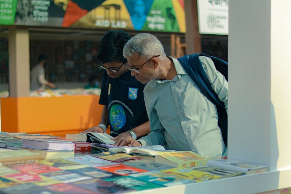 Personas ojeando libros en un puesto al aire libre