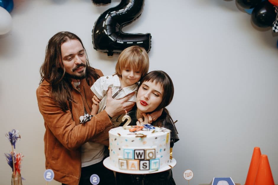 Una familia celebrando cumpleaños de niño con pastel