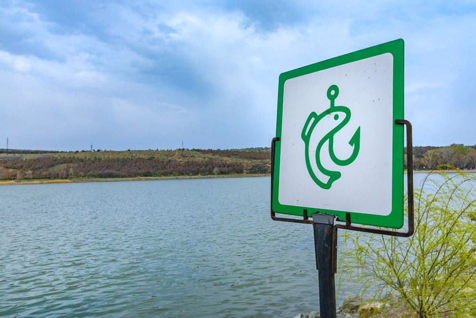 Señalética verde y blanca junto a un lago, en la sala de chat de Pesca