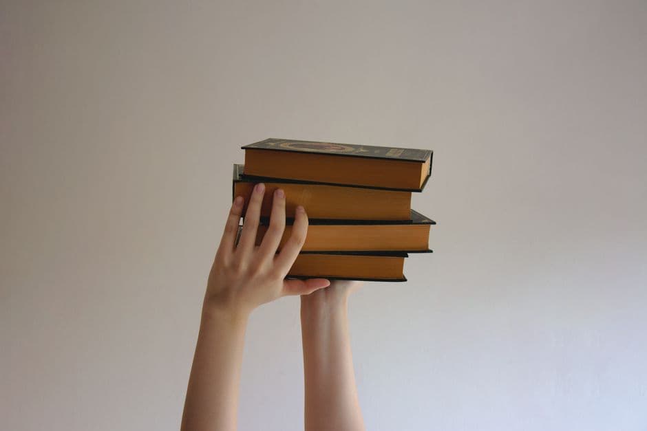 Una persona sostiene libros encuadernados en la sala de chat de Literatura