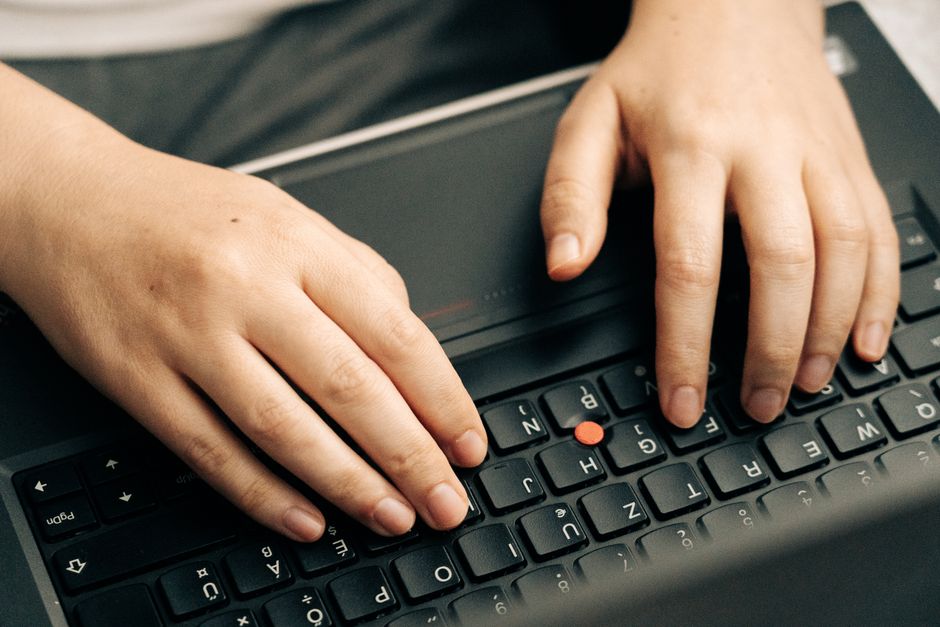 Persona tecleando en teclado de laptop, en la sala de chat de Chat sin registro