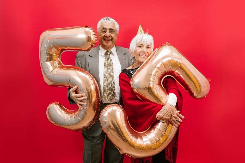 Una pareja sonriente de cincuentones con globos, en la sala de chat de Mayores de 50