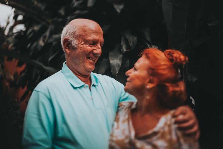Una pareja de ancianos sonrientes abrazándose en la sala de chat de Mayores de 60