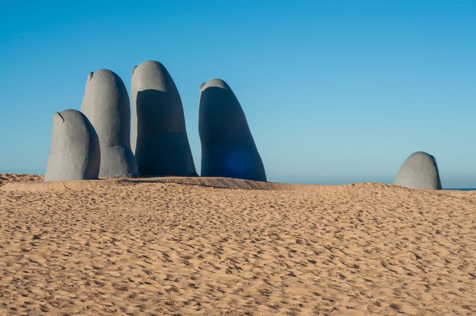 Dedos sobre arena y mar en Punta del Este, en el chat de Las Piedras