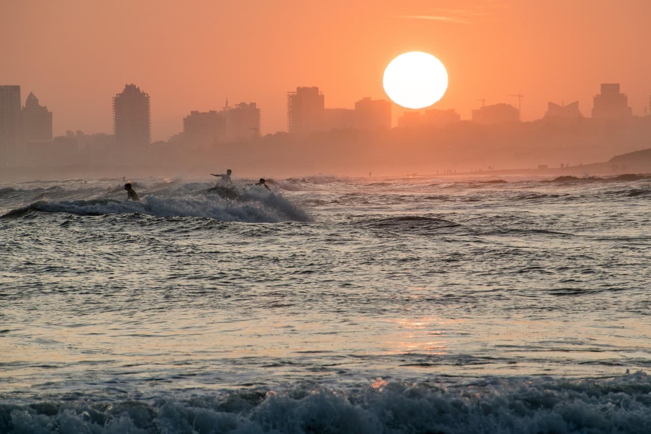 Silueta de un surfista en la playa al atardecer, en el chat de Ciudad del Plata