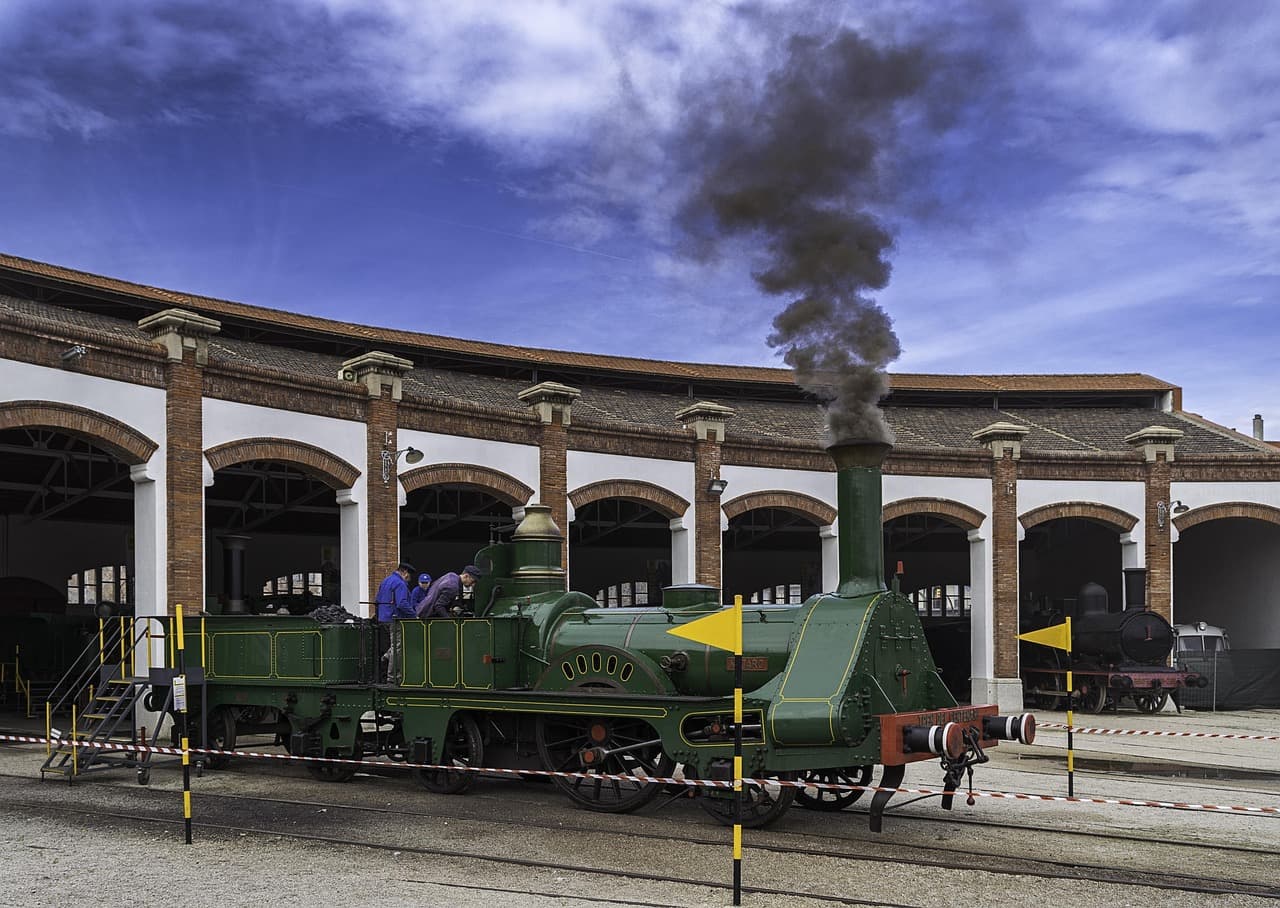 Tren de carga en vía férrea con locomotora, paisaje rural de fondo, en el chat de Vilanova i la Geltrú