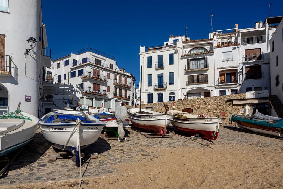 Barcas en la orilla y edificios blancos en Calella, en la sala de chat de Calella