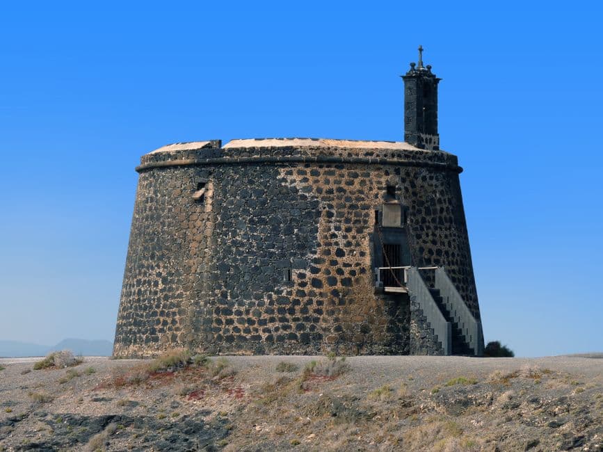 Castillo junto al mar y acantilados bajo cielo azul, en la sala de chat de Yaiza