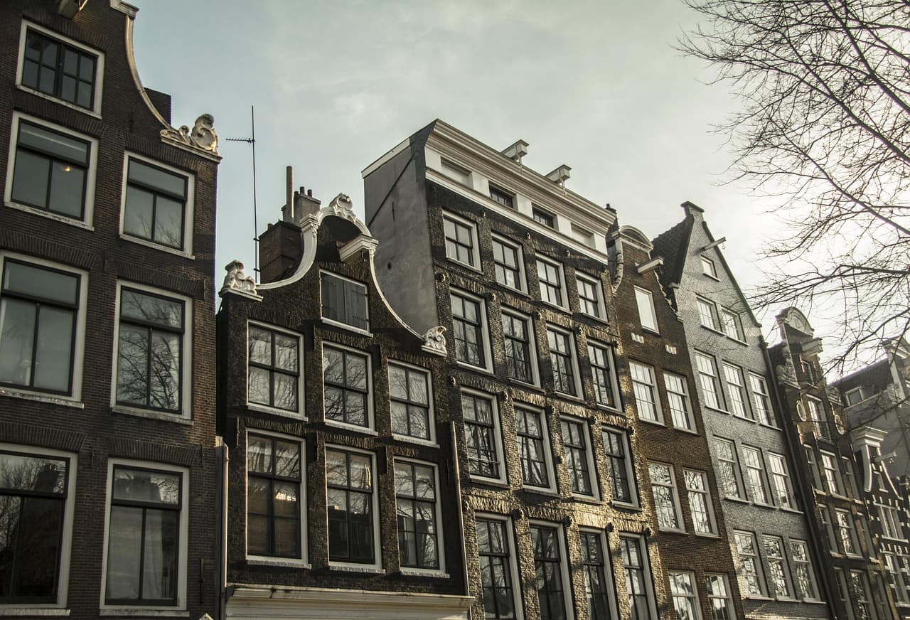 Calle empedrada con casas de fachadas estrechas y canales, en la sala de chat de Mungia