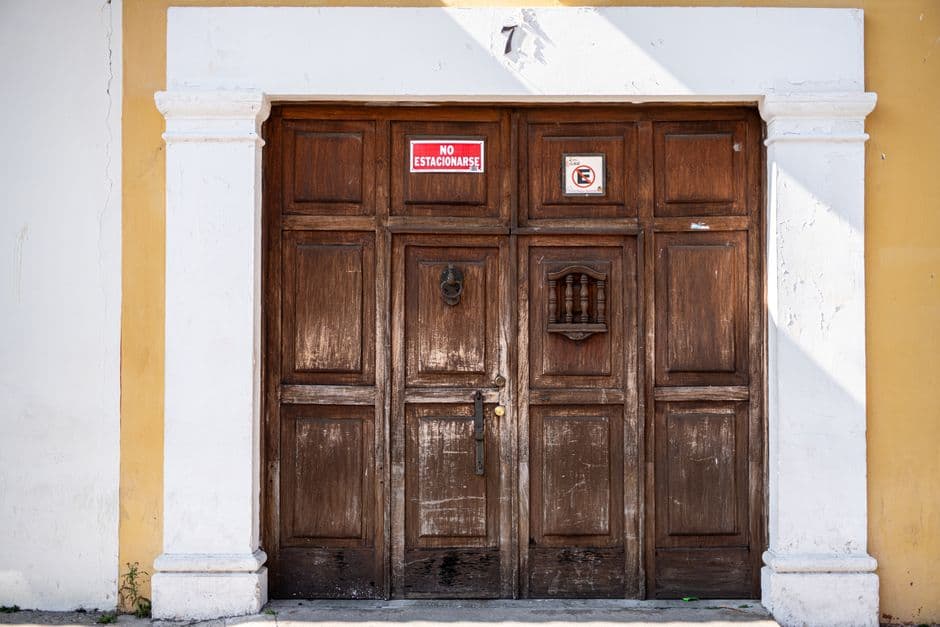 Puerta de madera rústica en una pared de piedra, en la sala de chat de Antigua