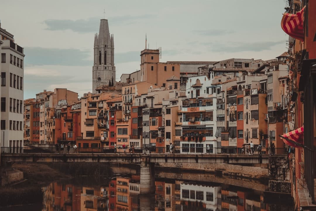 Edificios altos rojizos y marrones bajo cielo blanco, en la sala de chat de Teror