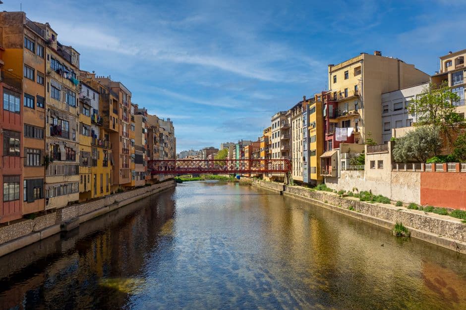 Edificios coloridos bajo cielo azul junto al río Onyar en Girona, en el chat de Argentona