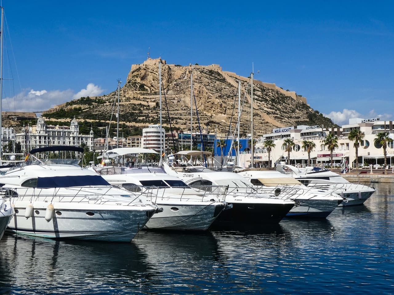 Vista de Alicante con edificios, mar y cielo azul, en el chat de Benaguasil