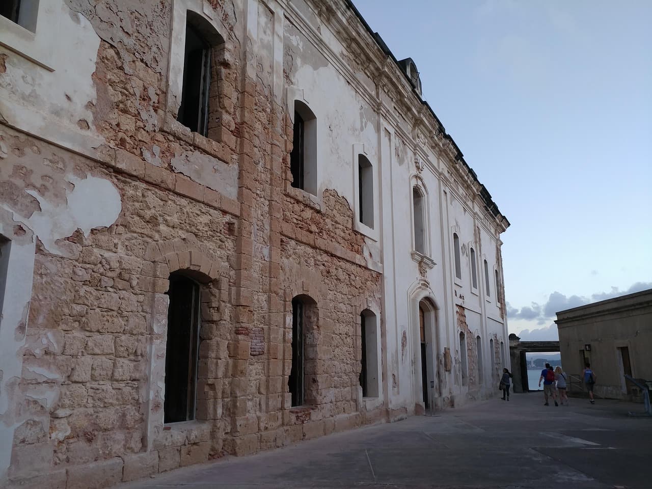 Fortaleza histórica de piedra con murallas y torres, rodeada de vegetación tropical, en el chat de Puerto Rico