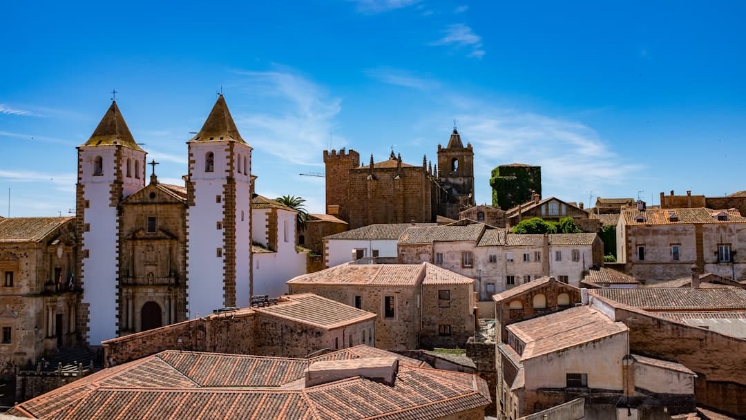 Edificios de estilo variado bajo cielo azul brillante, en la sala de chat de Cáceres
