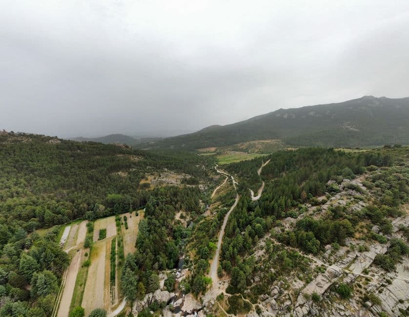 Valle verde entre montañas cubiertas de nieve y árboles, en la sala de chat de Manzanares