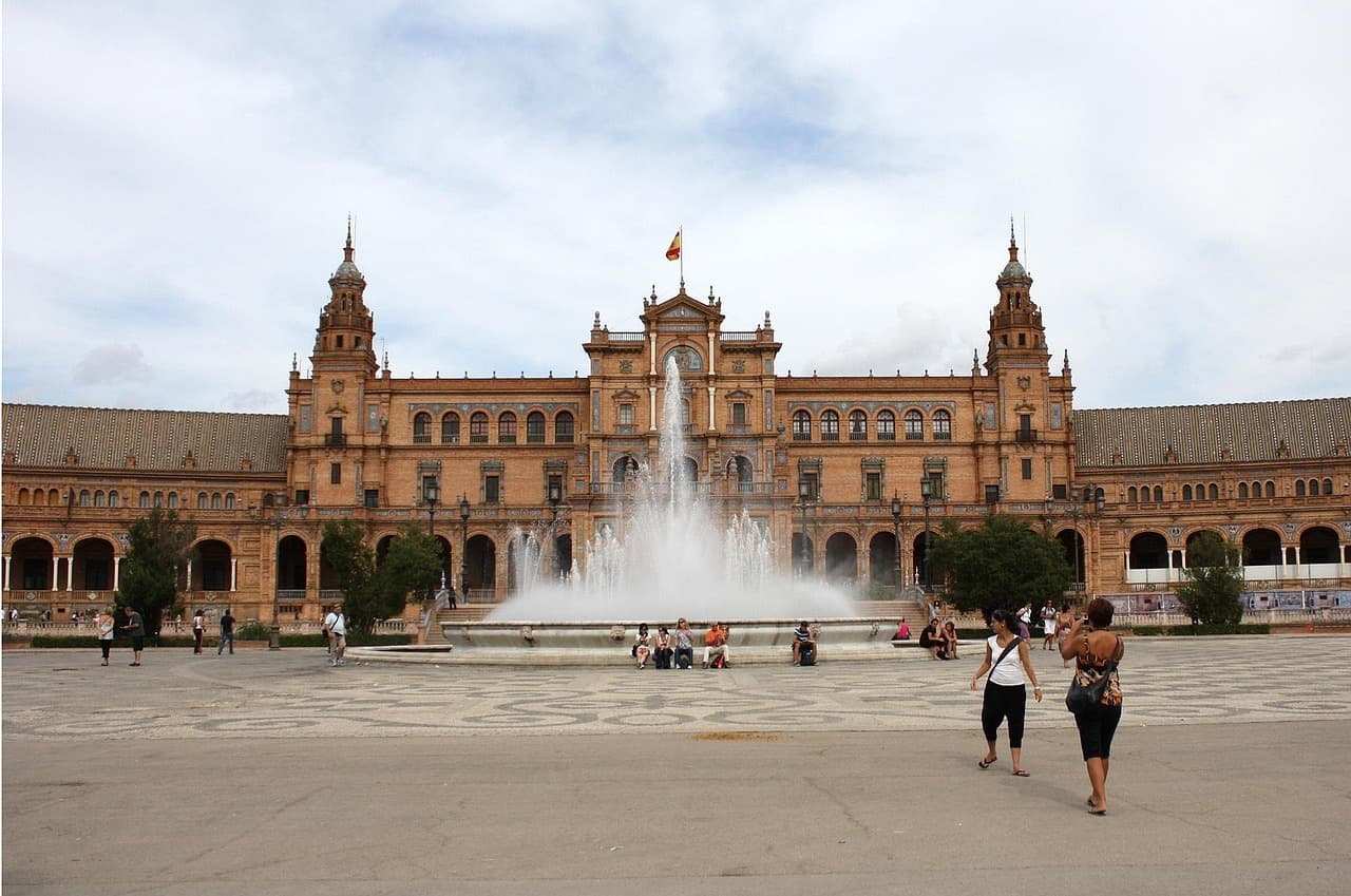 Plaza de Sevilla con fuente de agua y edificios históricos, en el chat de Espartinas