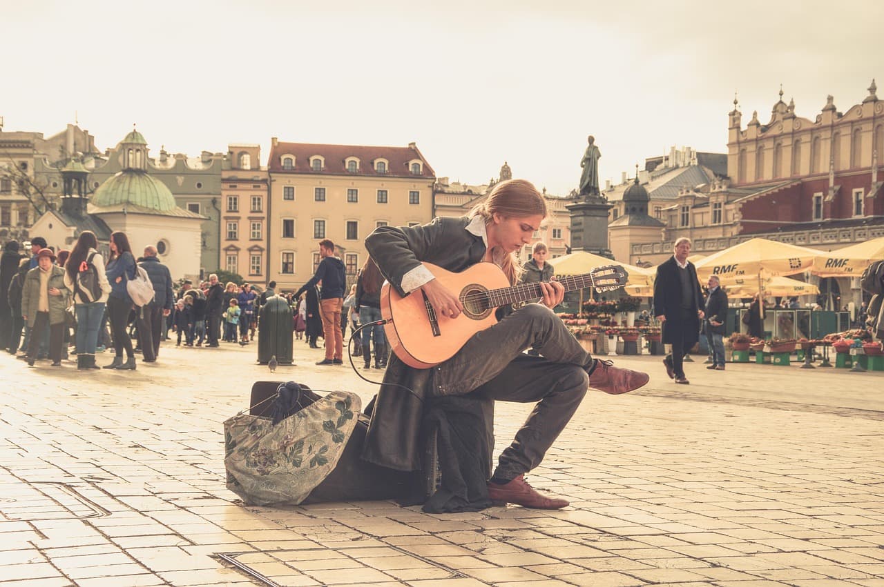 Guitarrista tocando en la calle entre la gente, en el chat de Bergara