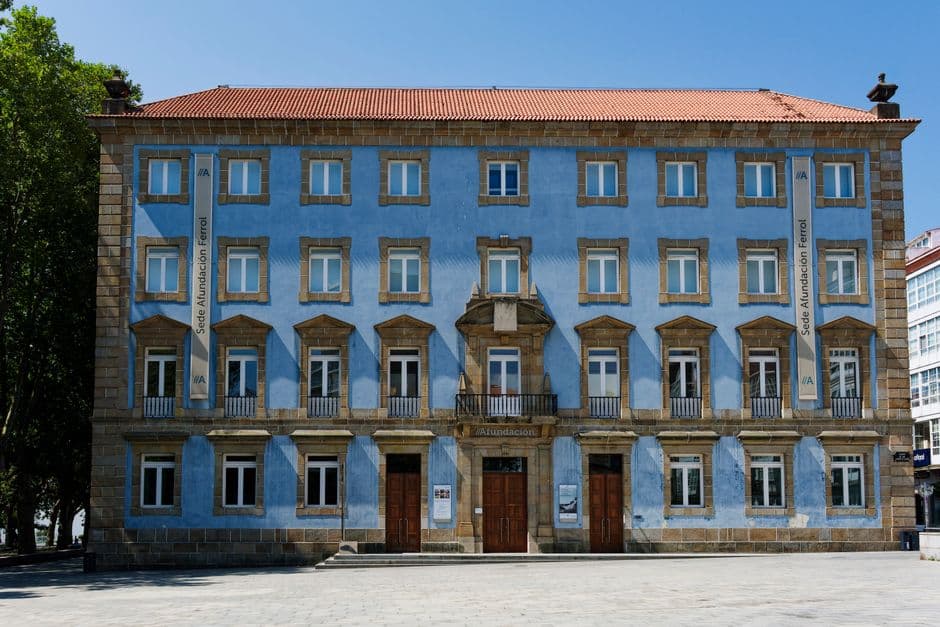 Edificio azul histórico en una plaza soleada, en la sala de chat de Ferrol