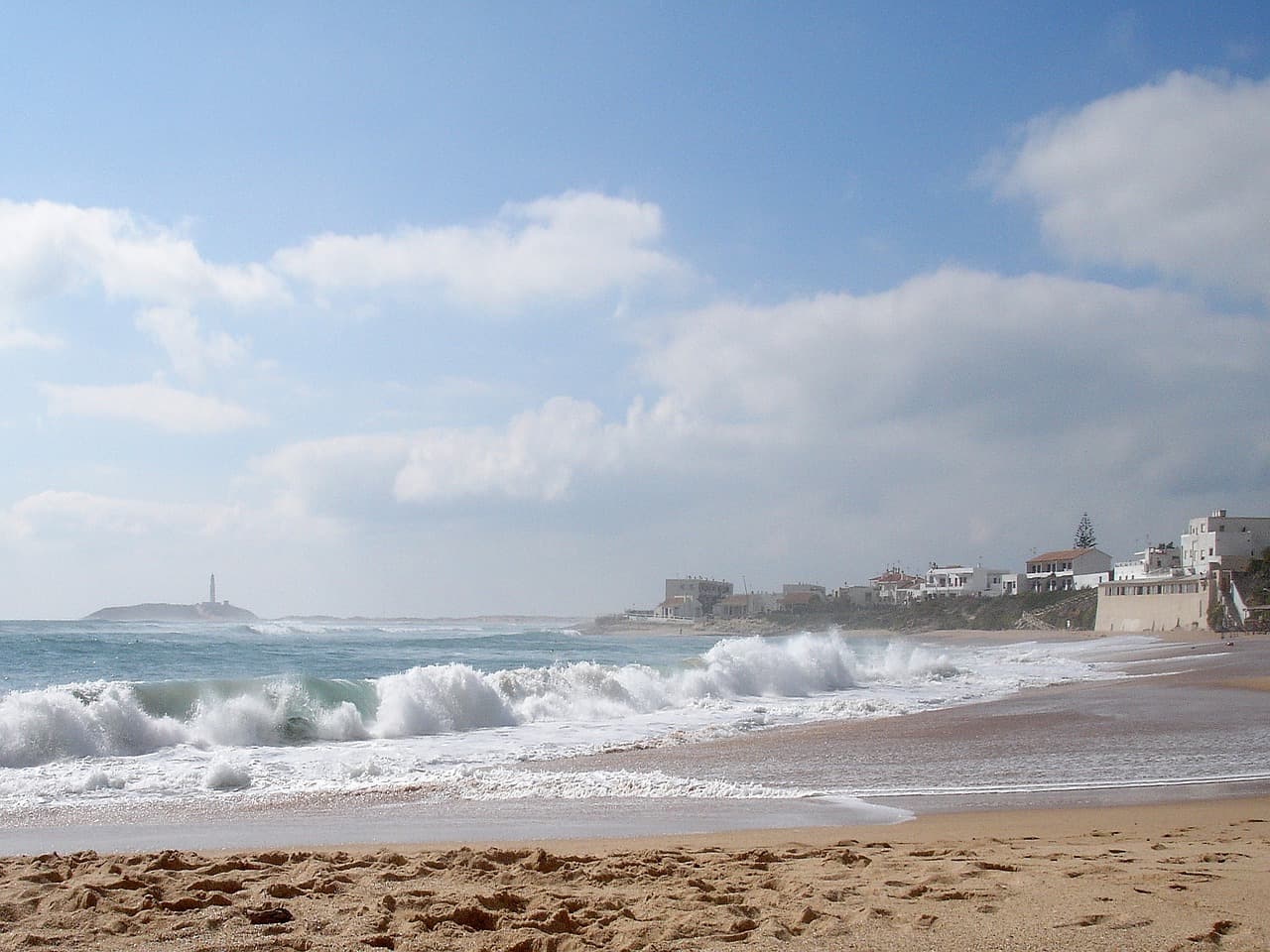 Playa de arena con cielo cubierto de nubes, en el chat de Palos de la Frontera