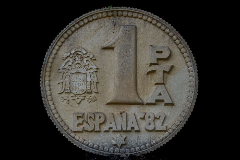 Escultura en piedra de una moneda de peseta, en la sala de chat de Pizarra