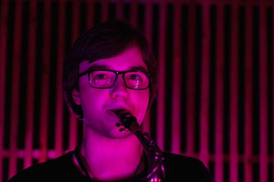 Hombre con camisa negra y gafas, en la sala de chat de Sax