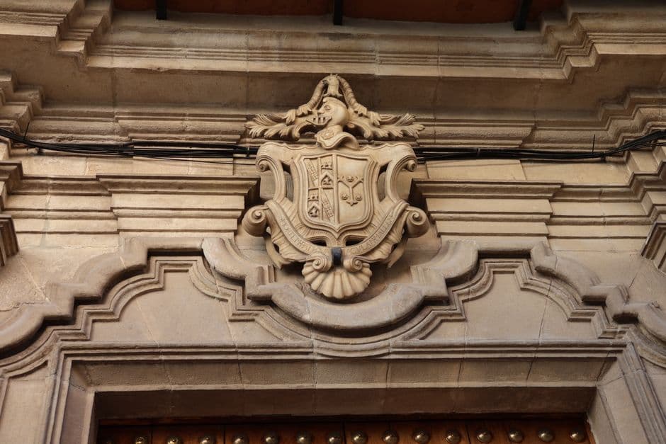 Escudo de piedra histórica en fachada andaluza, en la sala de chat de El Molar