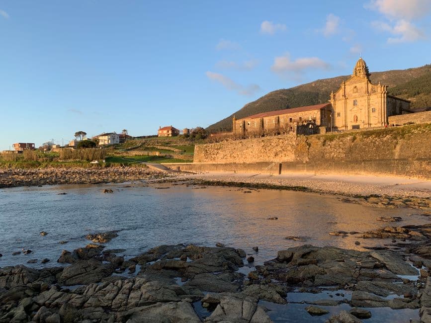 Iglesia histórica frente al mar con acantilados verdes, en la sala de chat de A Guarda