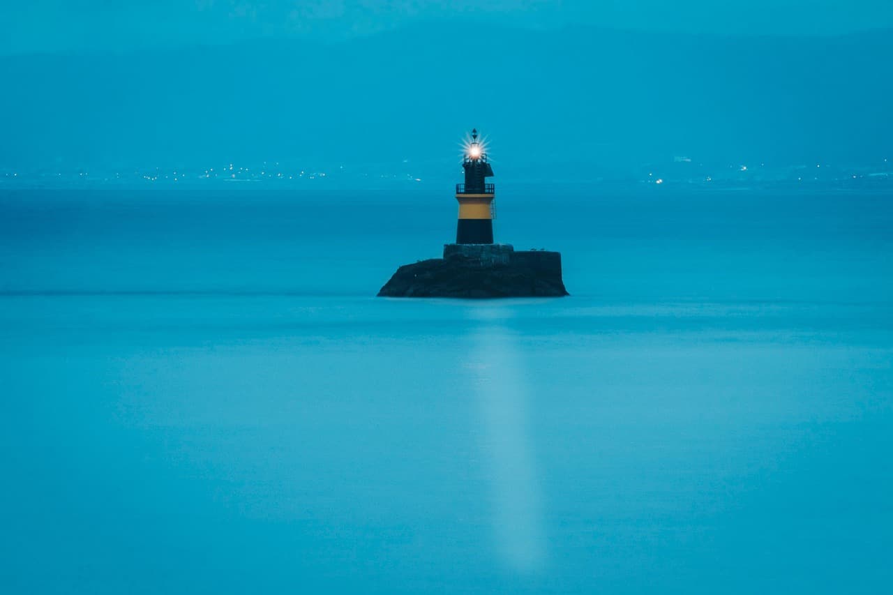 Farol de Burela sobre el mar azul bajo cielo despejado, en el chat de Burela