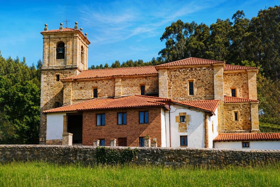 Un edificio de piedra con tejado rojo, en el chat de Santa Comba