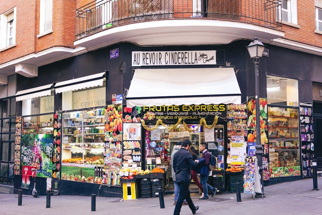 Hombre caminando junto a un puesto de frutas y verduras, en el chat de Hoyo de Manzanares