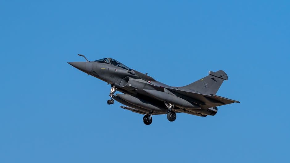 Un avión de combate volando sobre un paisaje llano, en el chat de Vila-real