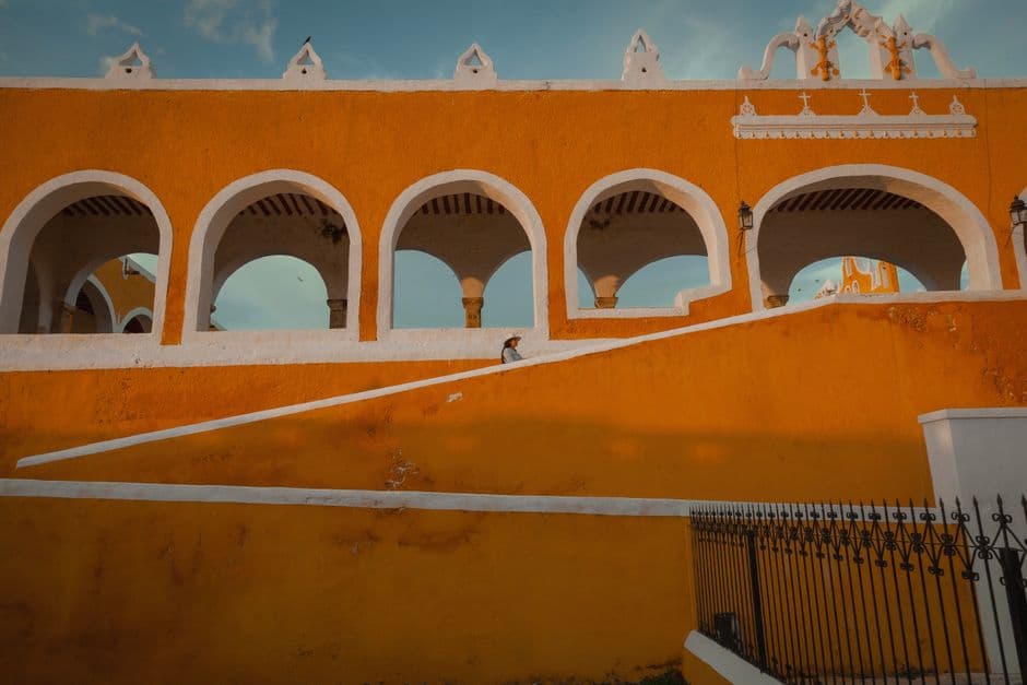 Una persona caminando por las escaleras de un edificio naranja, en el chat de San Antonio la Isla